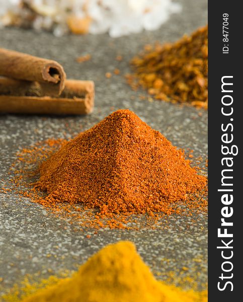 Colorful piles of ground spices on grey background