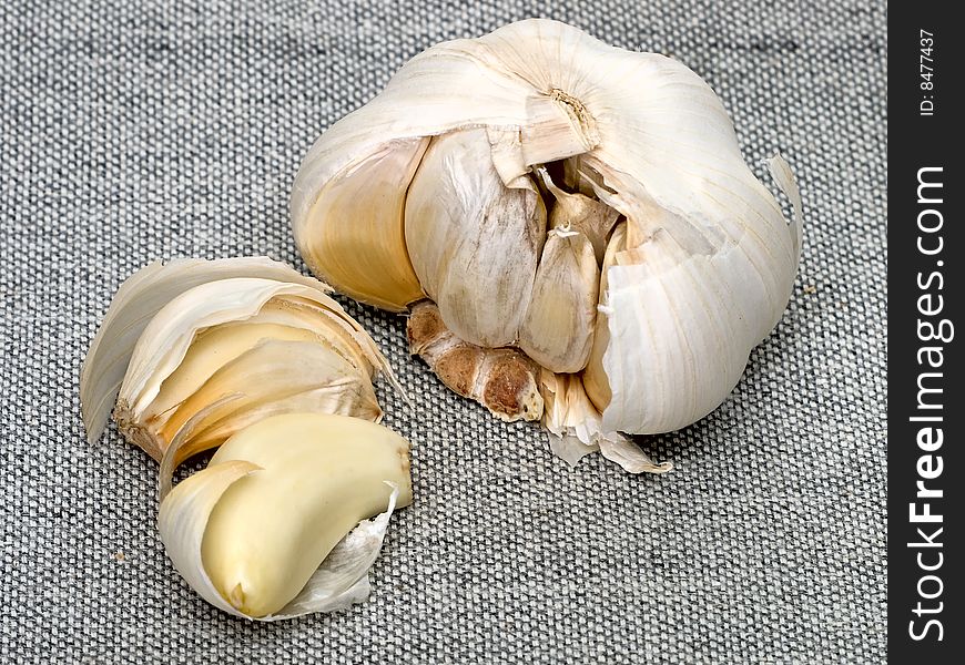 Cloves And Bulb Of Garlic Over Grey Sackcloth