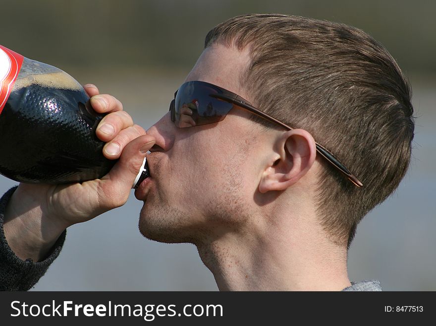 Young man drinks from a bottle