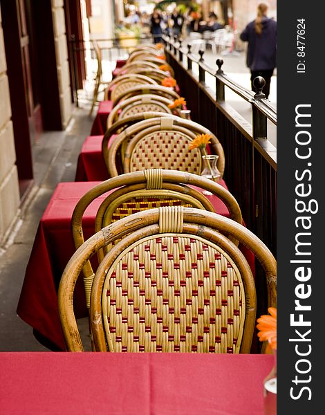 Tables and chair at an outside cafe with orange flowers. Tables and chair at an outside cafe with orange flowers