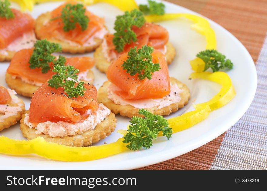 Smoked salmon and cream cheese on mini crackers with freshly cracked black pepper and garnishing of parsley. Smoked salmon and cream cheese on mini crackers with freshly cracked black pepper and garnishing of parsley