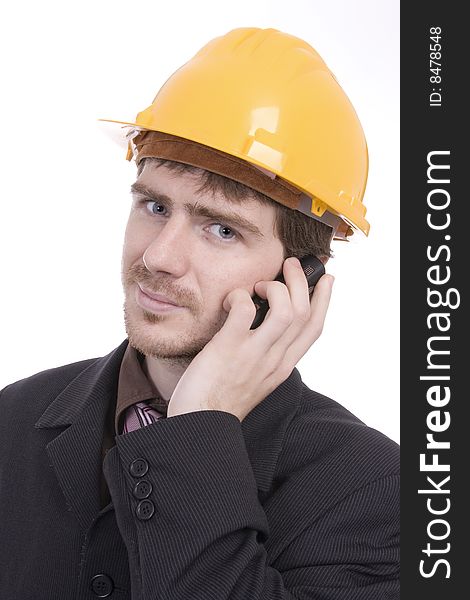 Portrait of successful business man with a yellow helmet, holding a cellphone