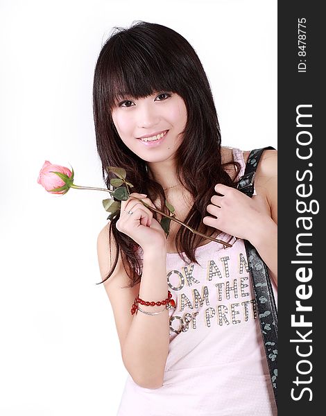 A beautiful Asian girl holds a pink rose on white background. A beautiful Asian girl holds a pink rose on white background.
