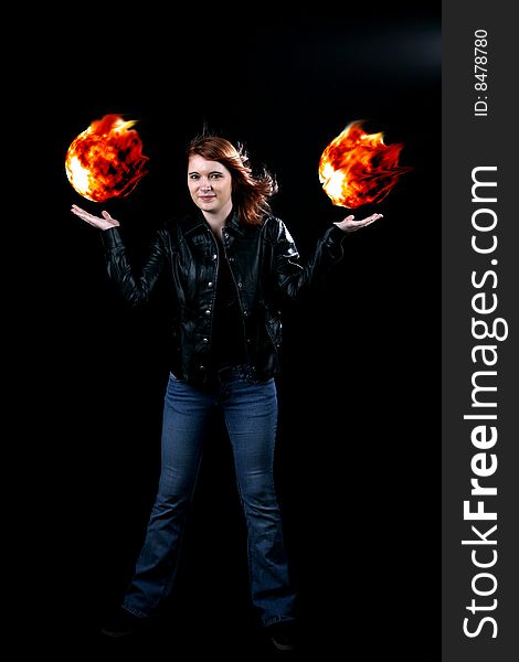 Teenage girl in black jacket holding floating fireballs in her hands. Teenage girl in black jacket holding floating fireballs in her hands
