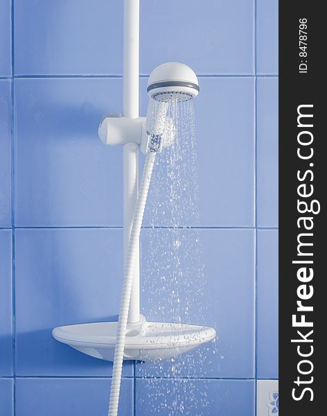 White shower and drops of water on blue tiling background