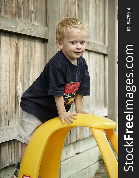 Color image of a young boy clinging on a toy car. Color image of a young boy clinging on a toy car.
