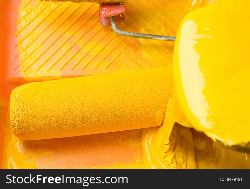 Painting roller in yellow paint