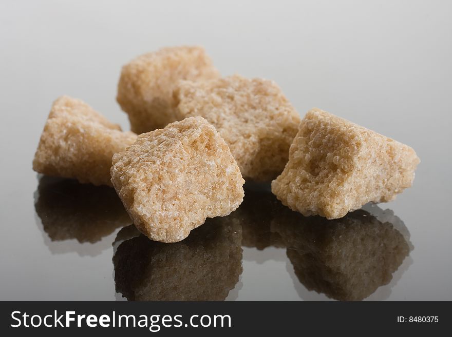 Brown sugar crystals on glass background