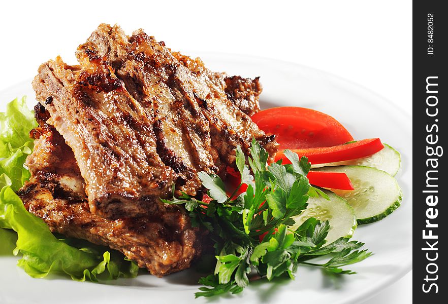 Beef (or Pork) Grilled with Greens and Vegetables on a Plate. Isolated on White Background