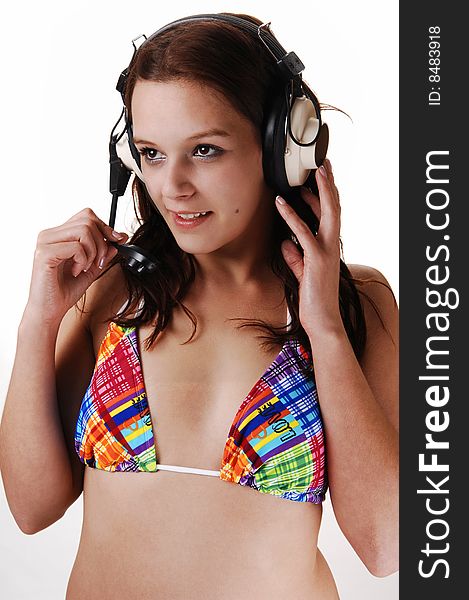A lovely young girl in bikini listen to music with her big earphones and 
auburn long hair in close-up. A lovely young girl in bikini listen to music with her big earphones and 
auburn long hair in close-up.