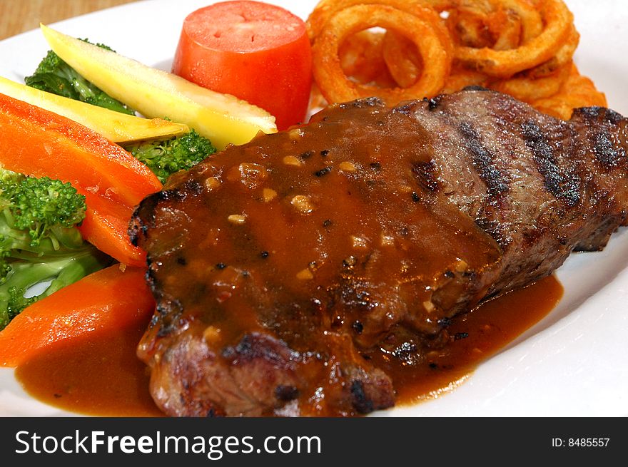 Steak with vegetables and curly fries
