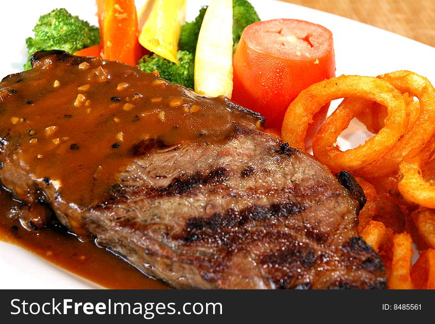 Steak with vegetables and curly fries