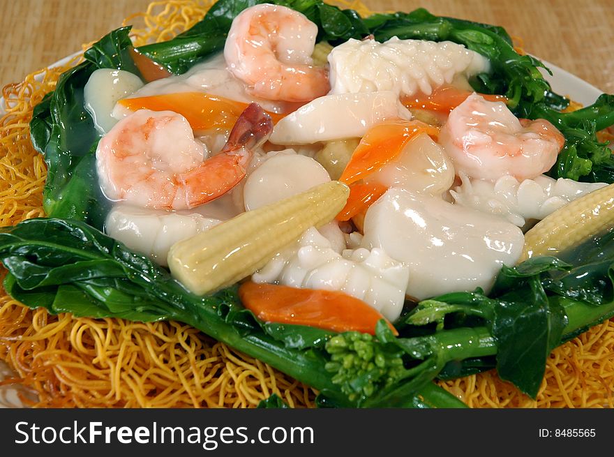 Glazed seafood over spinach and crispy noodles