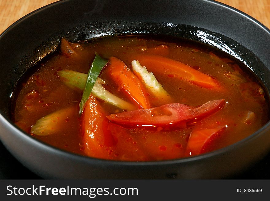 Vegetable soup in a black bowl