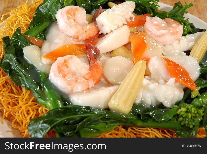 Glazed seafood over spinach and crispy noodles. Glazed seafood over spinach and crispy noodles