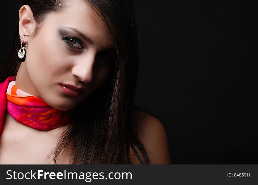 Beautiful brunet woman in red scarf at black background. Beautiful brunet woman in red scarf at black background