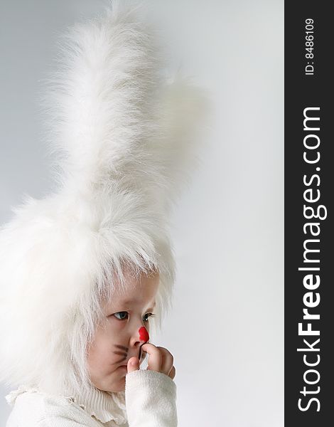 Little girl in a white downy bunny costume.