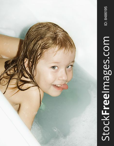 Small girl playing in the bathtub with a bucket. Small girl playing in the bathtub with a bucket