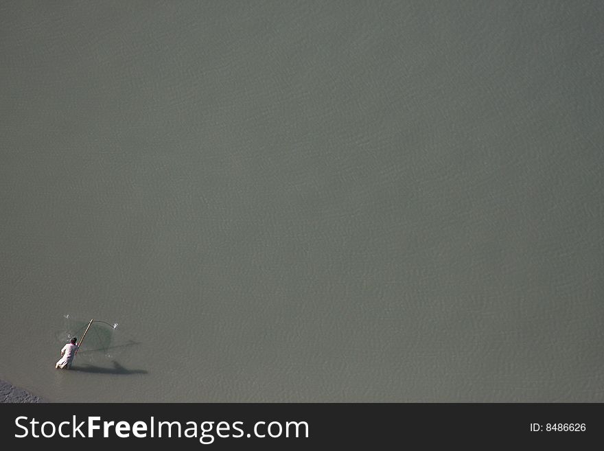 A solo fisherman fishing alone in a bay.