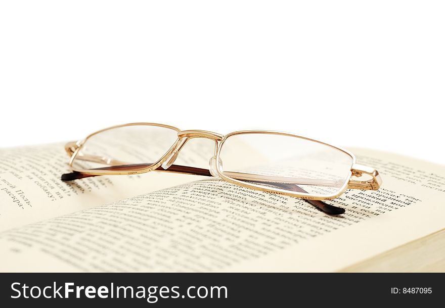 Glasses on book isolated on white