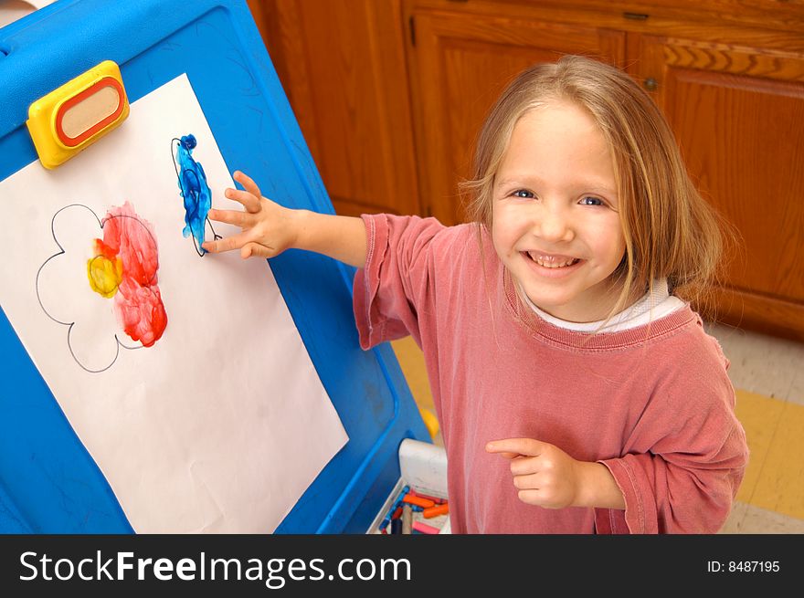 Exploring her creativity, a young girl spends part of her day finger painting.