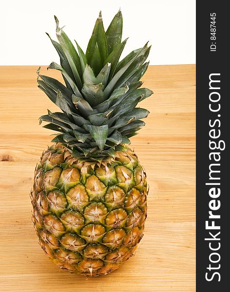 Whole pineapple fruit on a wood table and white background,check also