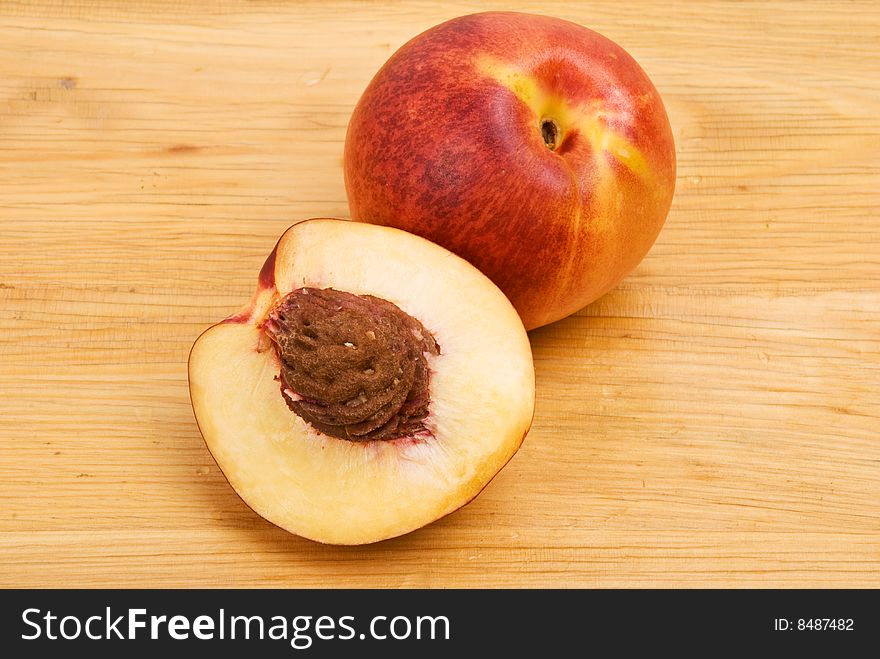 Close up of fresh nectarine full and slice with stone on a wood table,check also <a href=http://www.dreamstime.com/healthy-food-rcollection8217-resi828293>Healthy food</a>