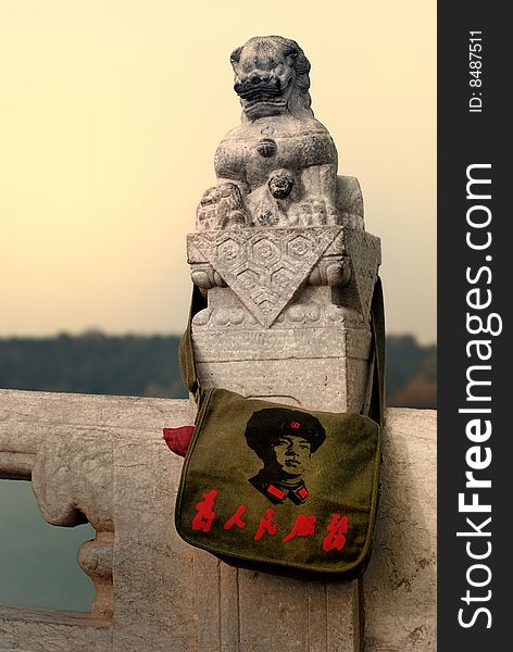 A old Satchel was hung on a statue of stone lion. A old Satchel was hung on a statue of stone lion.