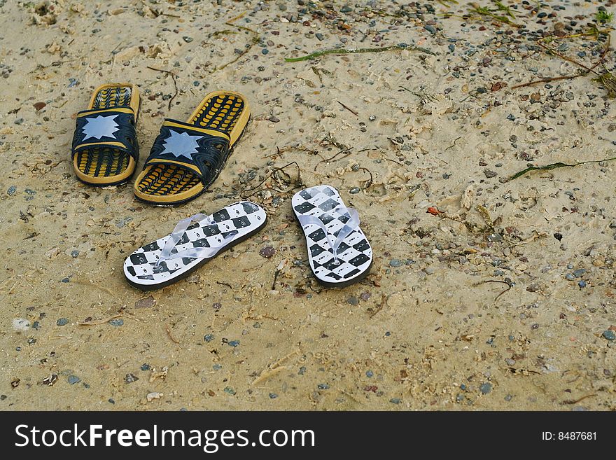 Womens and mens sandals on the beach. Womens and mens sandals on the beach