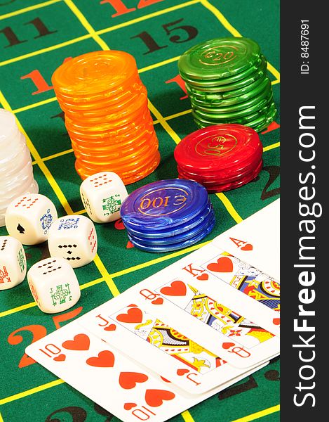 Casino chips,playing bones and royal flash combination on green felt. Casino chips,playing bones and royal flash combination on green felt