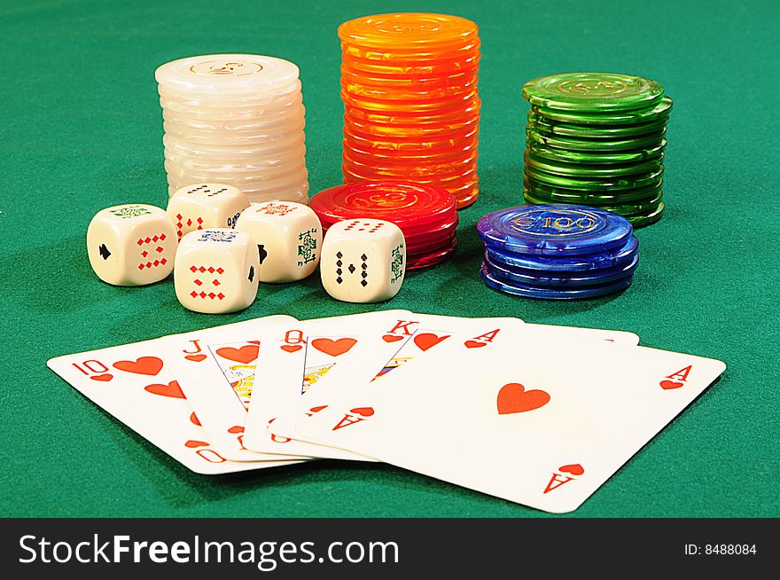 Casino chips,playing bones and royal flash combination on green felt. Casino chips,playing bones and royal flash combination on green felt