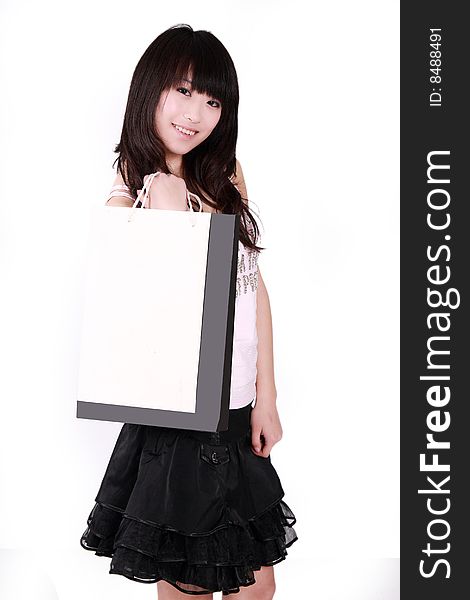 A beautiful Asian girl  holds a shopping bag on white background. A beautiful Asian girl  holds a shopping bag on white background.