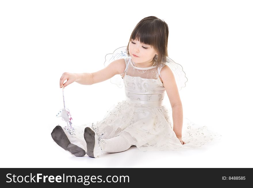Little girl with angel wings casting spell on her dancing slippers. Little girl with angel wings casting spell on her dancing slippers