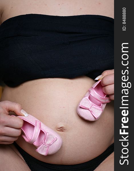 Pregnant woman with pink small shoes. Pregnant woman with pink small shoes.