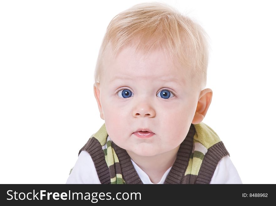 Sad little boy in a green vest on white background