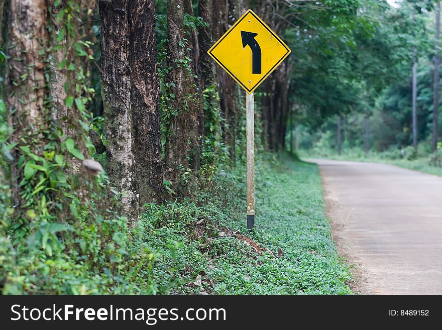 Left Curve Ahead on the road in the forest