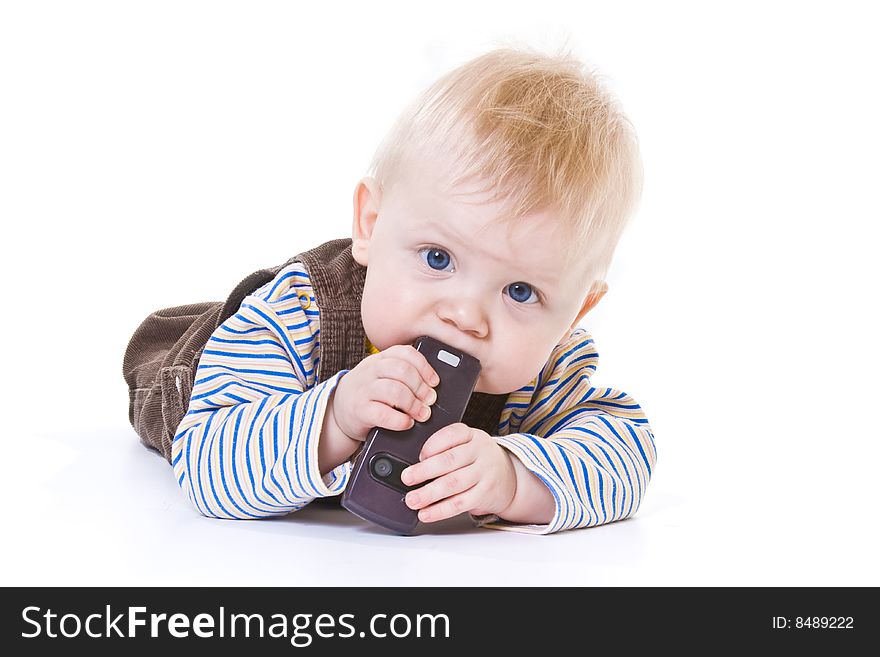 Little boy lies and gnaws cell phone on white background. Little boy lies and gnaws cell phone on white background