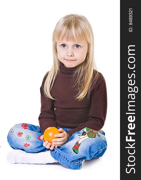 Little blonde girl with orange in hands on white background