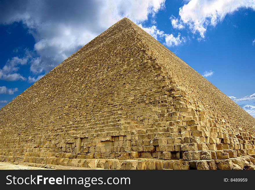 Pyramid in giza with blue and cloudy sky