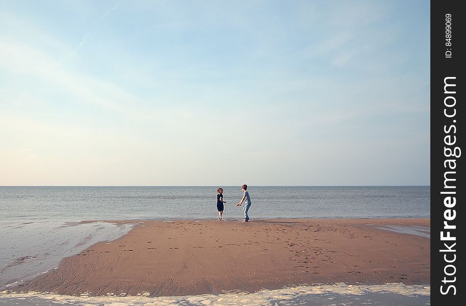 Two Children Playing On A Beach
