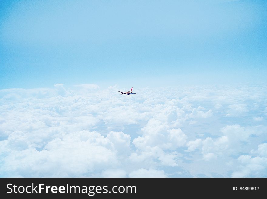 Airplane Flying Above Clouds