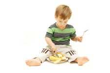 Young Boy Eating Fruits With Fork And Knife Stock Photo