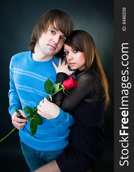 Beautiful couple with rose, studio shot