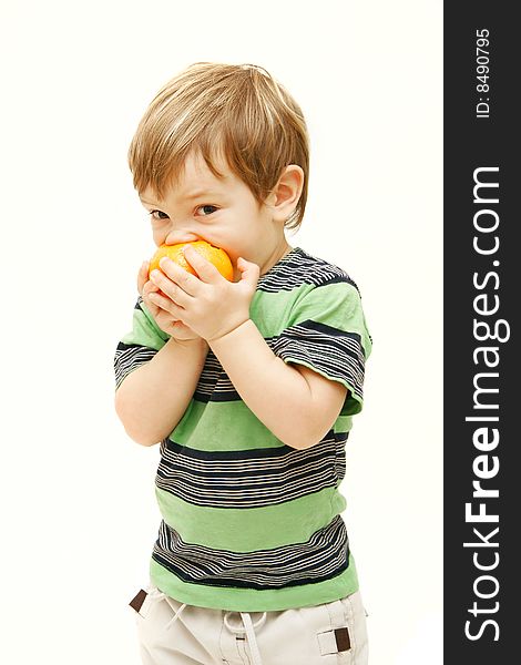 Young boy eating orange over white