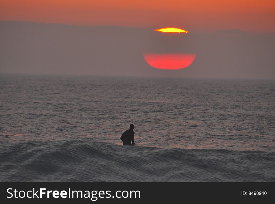 Surfer waiting for waves at dawn