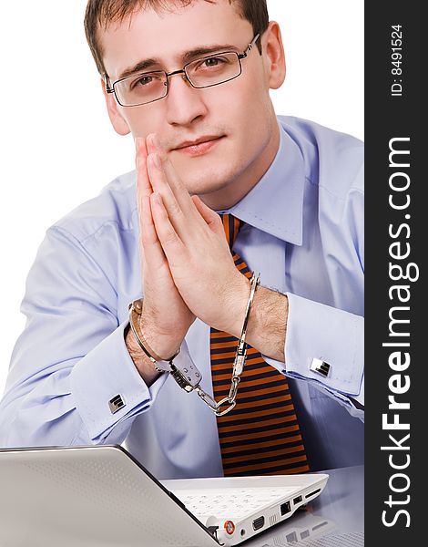 Handsome young businessman bound to laptop with handcuffs. Handsome young businessman bound to laptop with handcuffs