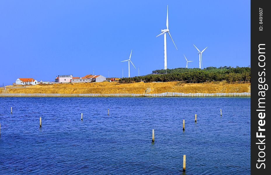 The wind-driven generator group in the seashore, provides the energy supply for the nearby city.
