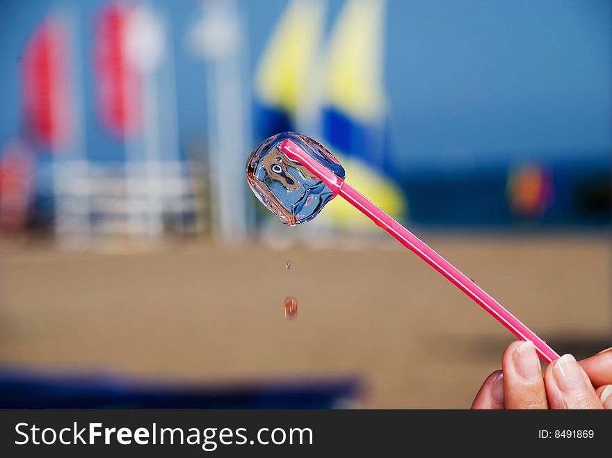 Ice cube melting on hot beach. Ice cube melting on hot beach