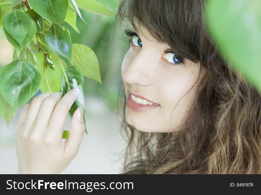 Girl with blue eyes in the foliage