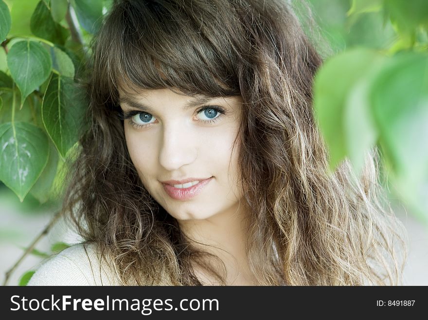 Picture of beautiful girl with blue eyes in the foliage